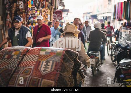 Marrakech, Morocco - APRIL 26 2019: citizens and tourists walking in the crowded streets of center Medina during the day Stock Photo