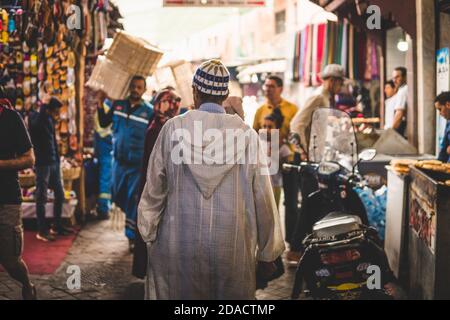 Marrakech, Morocco - APRIL 26 2019: citizens and tourists walking in the crowded streets of center Medina during the day Stock Photo