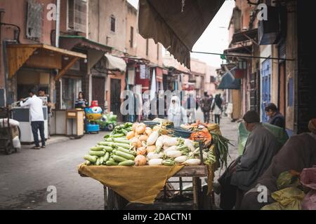 Marrakech, Morocco - APRIL 26 2019: view of a salesman and his vegetables and fruits shop in the middle of Medina Stock Photo