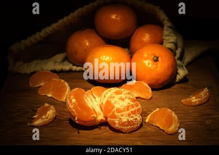 Mandarins on wooden board and in fabric bag Stock Photo