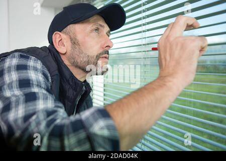 man installing roller shutter on window Stock Photo