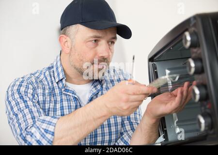 male technician repairing microwave oven Stock Photo