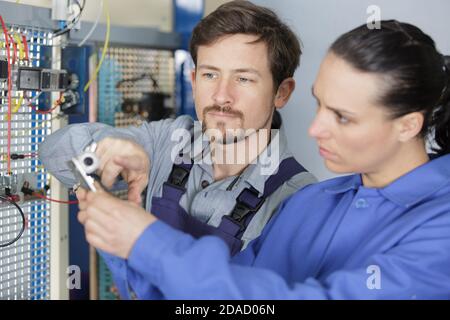 woman working on electronic circuit under supervision Stock Photo