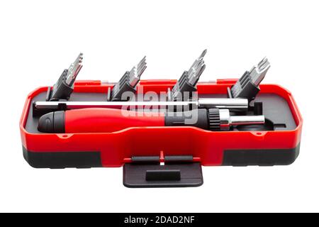 a set of working tools with a screwdriver and bits for repair in an open plastic box with iron nozzles, an object isolated on a white background view. Stock Photo