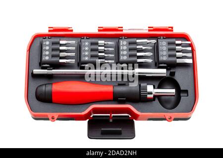 a set of working tools with a screwdriver and bits for repair in an open plastic box with iron nozzles, an object isolated on a white background view. Stock Photo