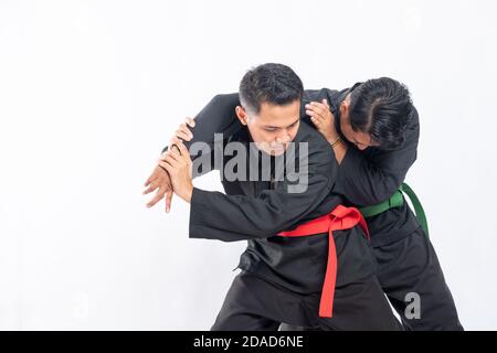two fighters in pencak silat Hitam uniform fight in low stance and side ...
