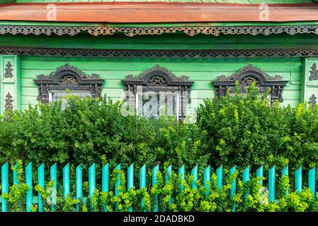 Facade of Russian rural house with platbands on windows in summer sunny day Stock Photo