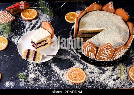 New Year's cake is decorated with gingerbread houses, oranges. The veccis ate, the indigridents on the table. Flat lay Stock Photo