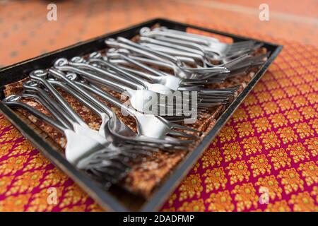 Stainless steel fork in wooden tray on woven cloth Stock Photo