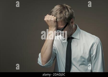 Stressed frustrated businessman making a facepalm gesture, he feels shameful for his mistake Stock Photo
