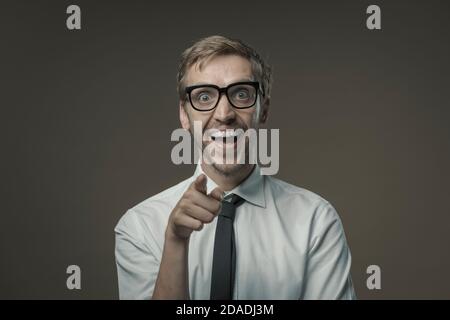 Businessman with glasses smiling and pointing at camera Stock Photo