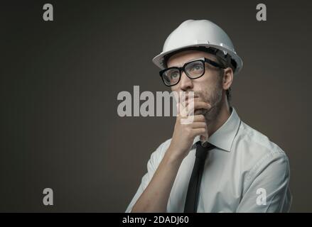 Construction engineer thinking with hand on chin: problem solving and planning concept Stock Photo