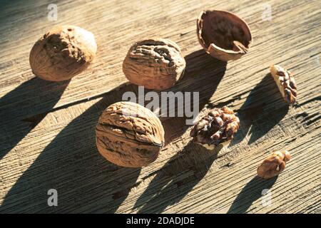 Walnuts lit by the sun on an old dark wooden surface Stock Photo