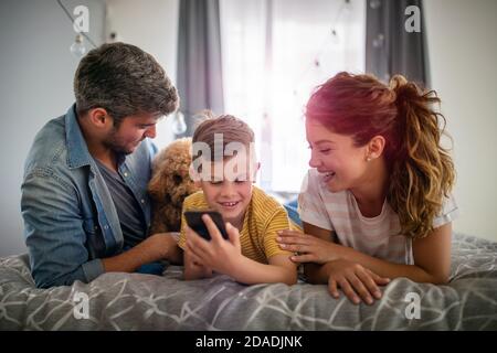 Happy family using digital technology decives for playing watching movies, relaxing at home. Stock Photo