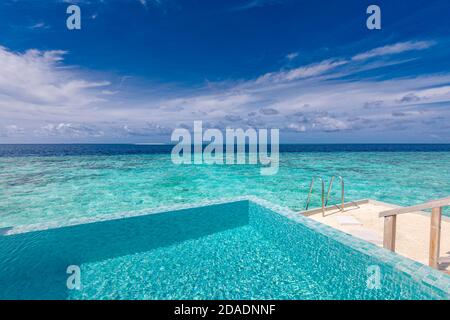 Infinity pool on the bright summer day. Infinity swimming pool in luxury hotel resort, tropical seascape, lagoon. Amazing summer vacation leisure view Stock Photo