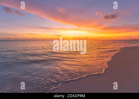 Beautiful sunset on the beach and sea. Tropical beach at beautiful sunset. Nature background. Exotic landscape, shore, coast, calm waves, soft sand Stock Photo