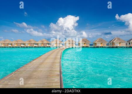 Overwater bungalows at Maldives islands. Stunning sea shallows with jetty and water villas. Amazing nature scenery, perfect summer travel vacation Stock Photo
