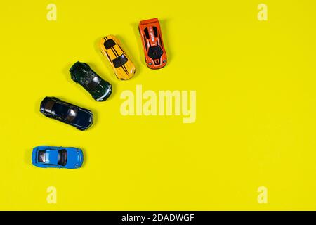 Colorful models of toys cars on a yellow background with room for text. Banner for toy store toy typewriter car Stock Photo