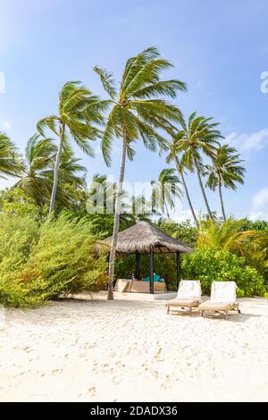 Two beach chairs on idyllic tropical white sand beach. Shadow from the palm trees. Summer landscape, tropical resort hotel beach landscape Stock Photo