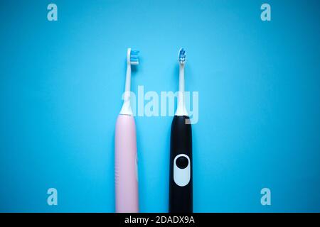 two ultrasonic electric toothbrushes on a blue background Stock Photo