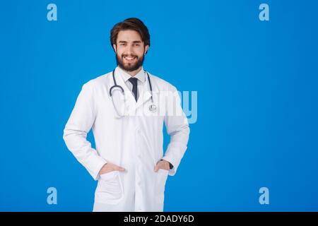 Young bearded doctor on a blue background. emotions of joy and a smile at the doctor looking at the camera Stock Photo