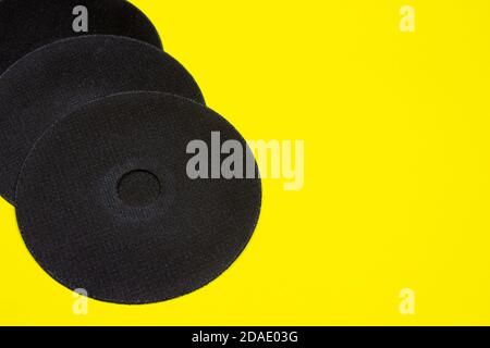 A cut-off wheel for a grinder tool on a yellow background with a place for copyspace text. Tools for construction and repair, workshop. Stock Photo