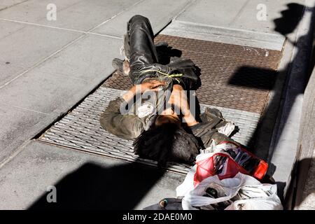 NEW YORK, USA - Sep 23, 2017: Manhattan street scene. A homeless man sleeps on the streets of Manhattan, NYC Stock Photo