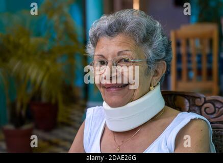 Smiling elderly woman wearing homemade looking cervical immobilizer collar Stock Photo