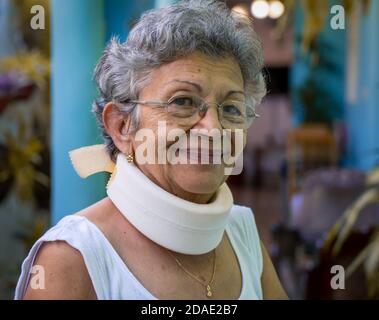 Smiling elderly woman wearing homemade looking cervical immobilizer collar Stock Photo