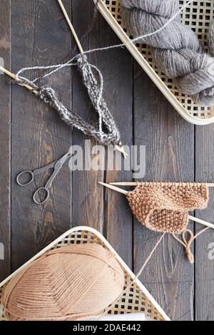 High angle view of baskets with balls of yarn and other sewing items on wooden table Stock Photo
