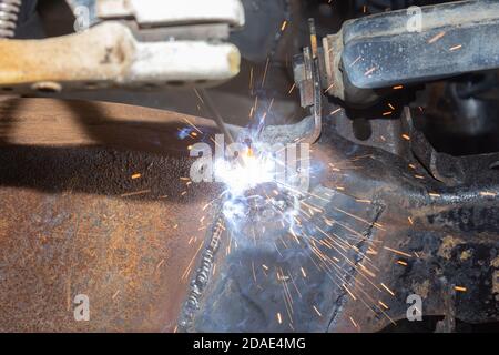 Welder Welding Bottom Car Chassis by Electric Welding Torch on Center Frame Stock Photo