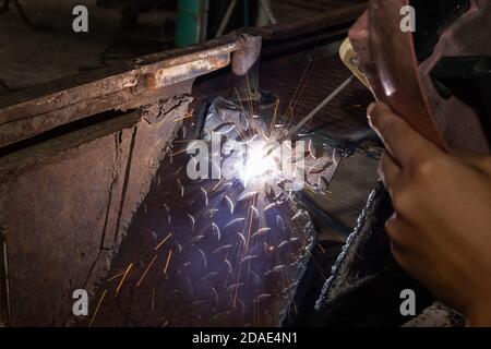 Welding Spark of Car Mudguard from Welder in Car Repair Shop in Zoom View Stock Photo