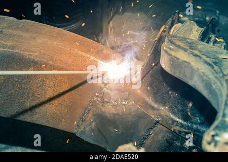 Welder Welding Bottom Car Chassis by Electric Welding Torch in Zoom View in Vintage Tone Stock Photo