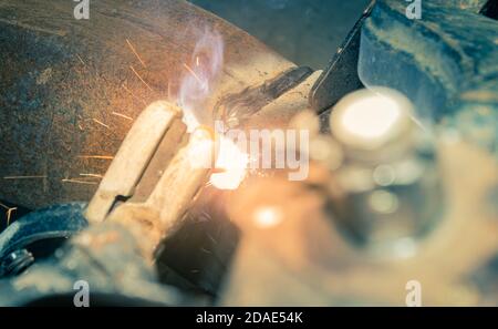 Welder Welding Bottom Car Chassis by Electric Welding Torch on Top View in Vintage Tone Stock Photo