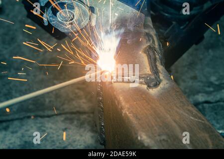 Zoom View Welding Bottom Construction of Car Chassis in Garage by Welder in Vintage Tone Stock Photo