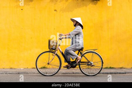 Hoi An Ancient Town, Vietnam, January 27, 2020 - Woman riding a bicycle without helmet in a street at Hoi An Ancient Town Stock Photo