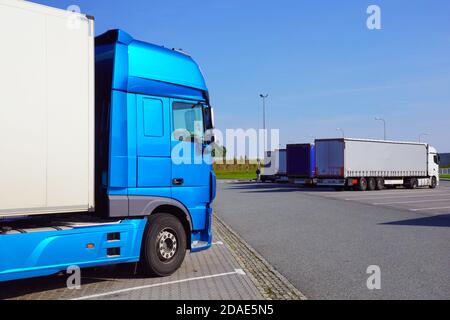 Truck stop. Various types and colors of cabins. Trucks parked in a row. Break in a trip. Stock Photo