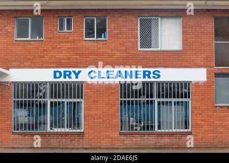 the side of a Dry Cleaners store in Forster, New South Wales, with steel security bars on the ground floor windows Stock Photo