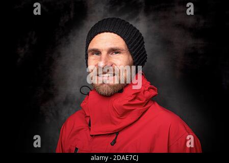 Handsome man in a knitted hat on a dark background Stock Photo