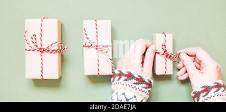 Banner with female hands tying a bow on a christmas gift. Stock Photo
