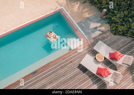 Breakfast in swimming pool, floating breakfast in luxurious tropical resort. Table relaxing calm pool water, healthy luxury breakfast and fruit plate Stock Photo