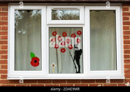Window decorated for remembrance day with poppies and a soldier silhouette, commemorating armistice during the 2020 coronavirus covid-19 pandemic, UK