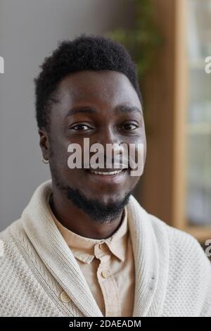 Portrait of African young man in white sweater smiling at camera Stock Photo