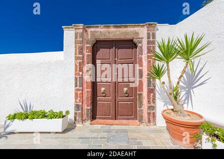 Old wooden door with white architecture in Santorini Greece. Sunny summer weather, vacation, Europe traveling destination, relax, background Stock Photo