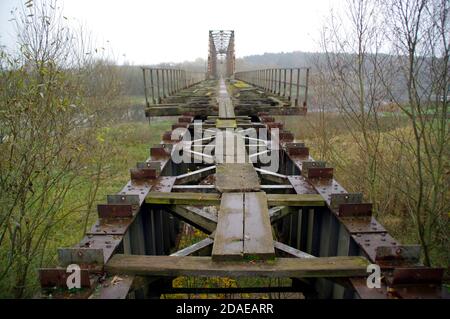 Old steel riveted bridge. Destroyed and forgotten river crossing. Old engineering. Stock Photo