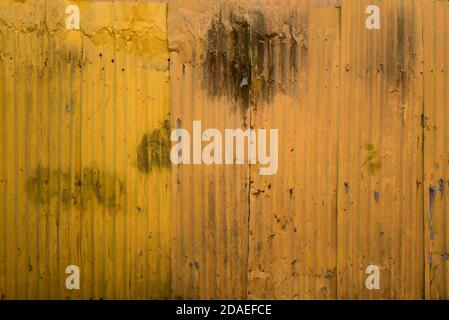 A Close Up Of A Fence Constructed Of Sheets Of Corrugated Metal Painted Yellow Stock Photo