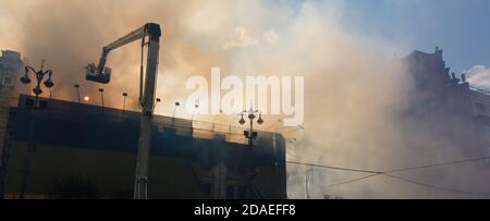 KIEV, UKRAINE - Jun 20, 2017: Ukrainian firefighters try to extinguish a fire in a three-story house on Khreshatyk street, the main street in Kiev. Fi Stock Photo