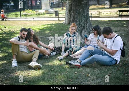 Using Internet With Friends Photo Group of friends using smartphones together. Young people addiction to ...