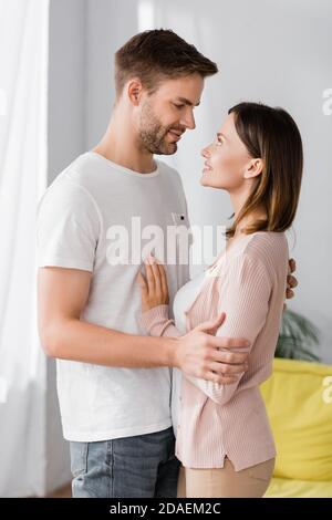 happy man and woman looking at each other while hugging at home Stock Photo