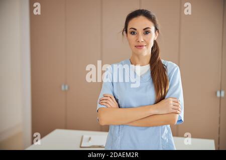 Young beautiful lady in medical uniform posing at office Stock Photo